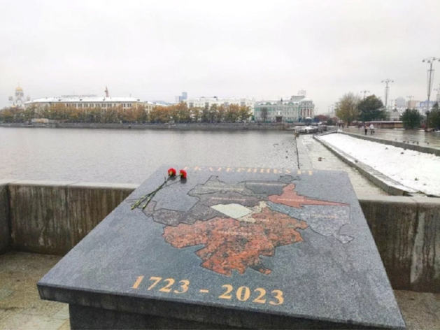 В центре Екатеринбурга установили гранитную доску. Люди несут к ней цветы